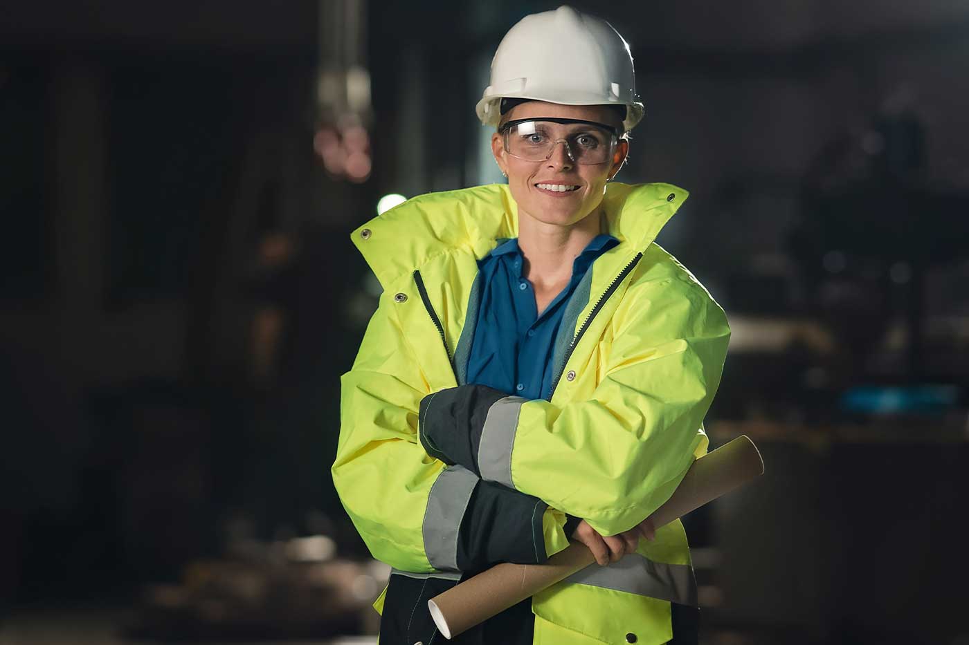 Smiling mine worker in a hard hat, safety glasses and hi-vis jacket